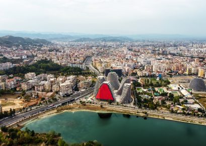 Aerial drone view of Tirana, Albania. City centre with modern buildings, residential district and greenery, lake
